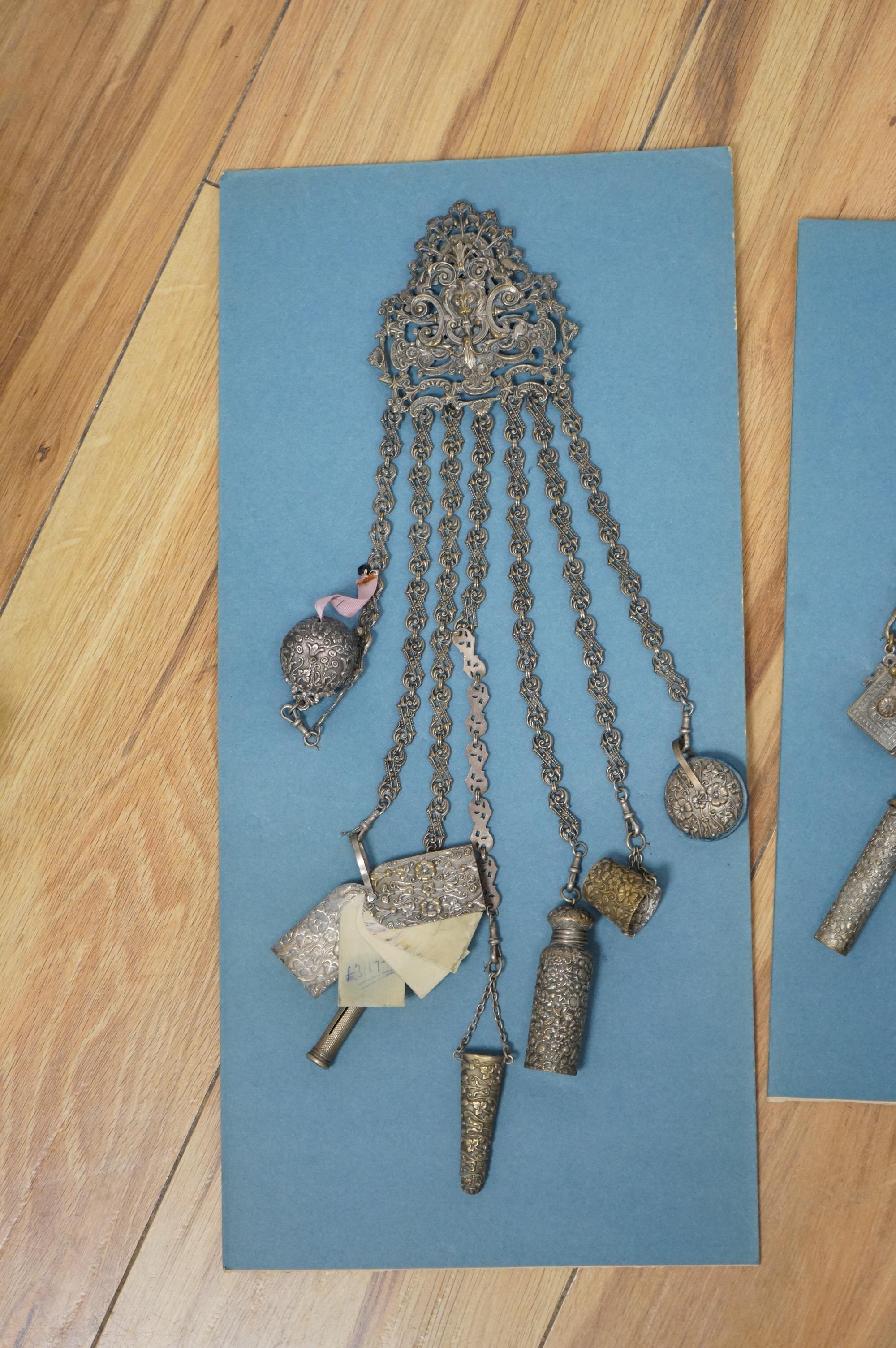 Four assorted 19th century base metal chatelaines, one with some silver implements